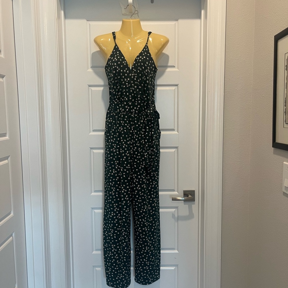 Wide leg jumpsuit. Adjustable spaghetti straps. Side pockets. Tie at waist.